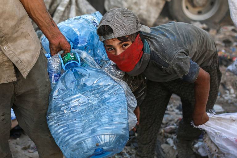 IRAQUE - Jovem catador iraquiano procura resíduos plásticos em lixão de Basra, cidade que tem o principal porto do país