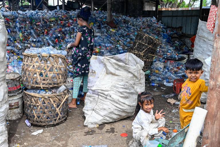 INDONÉSIA - Crianças brincam em galpão de triagem de resíduos recicláveis em Banda Aceh