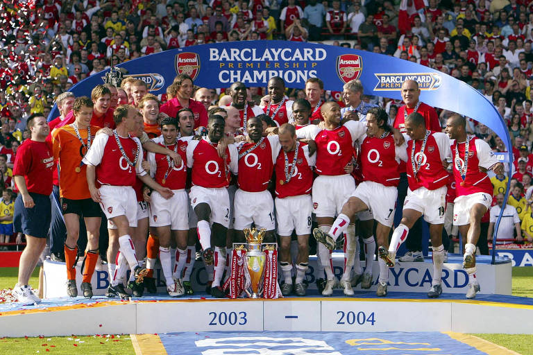 Jogadores do Arsenal comemoram lado a lado no pódio a conquista da Premier League de 2003/2004, na qual venceram de forma invicta
