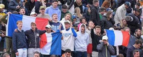 French fans with French national flags chant during France's Giovanni Mpetshi Perricard and Belgium's David Goffin's men's singles match on day three of the French Open tennis tournament at the Roland Garros Complex in Paris on May 28, 2024. (Photo by Bertrand GUAY / AFP)