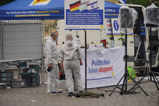 Police investigators work at the scene where a man attacked people at a far right-wing information stand of the Buergerbewegung Pax Europa in Mannheim