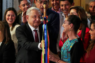 FILE PHOTO: Mexico's President Andres Manuel Lopez Obrador hands over the 