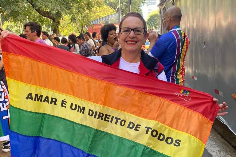 Mulher segura bandeira com os dizeres 'amar é um direito de todos'