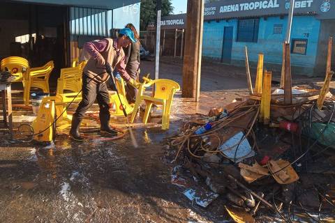 Moradores e comerciantes do bairro Farrapos, na zona norte de Porto Alegre, limpam imóveis neste sábado (1º), após enchente. Na foto, Rudimar Capalonga, 63, limpa seu bar perto da Arena do Grêmio.