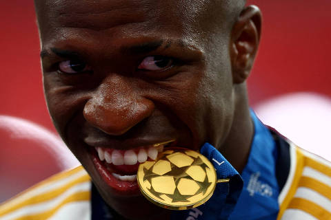Soccer Football - Champions League - Final - Borussia Dortmund v Real Madrid - Wembley Stadium, London, Britain - June 1, 2024 Real Madrid's Vinicius Junior poses with his winners medal in his mouth as he celebrates winning the Champions League REUTERS/Carl Recine     TPX IMAGES OF THE DAY