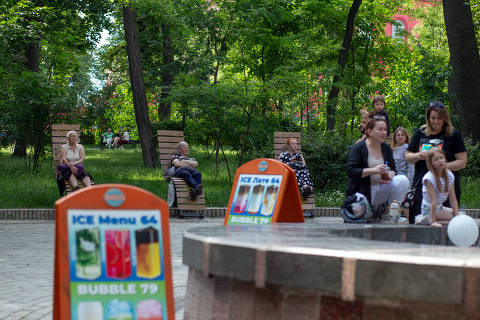Pessoas tomam sol em praça na região central de Kiev, na Ucrânia