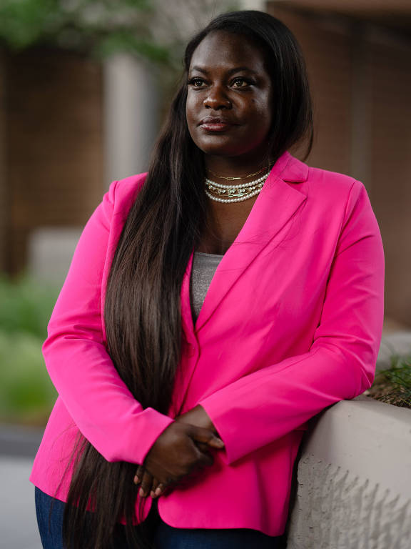 Raven Baxter é uma mulher negra que posa para foto vestindo um blazer rosa choque