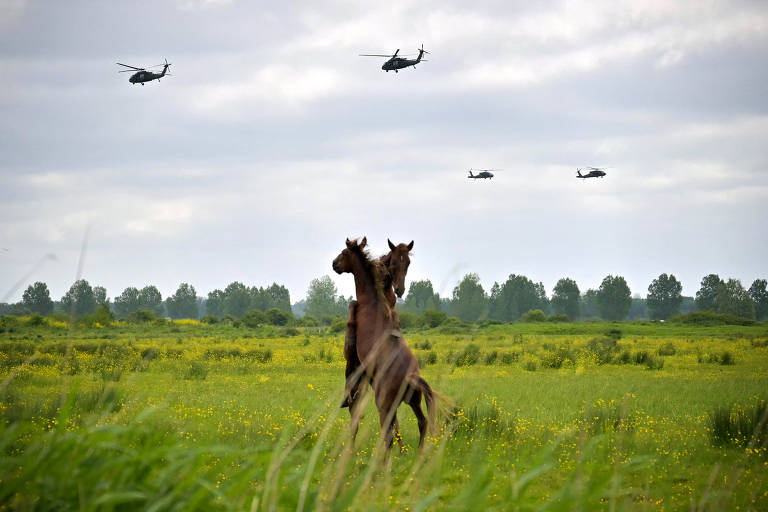 Helicópteros Black Hawk americanos voam sobre Carentan-les-Marais, França, como parte da celebração dos 80 anos do Dia D