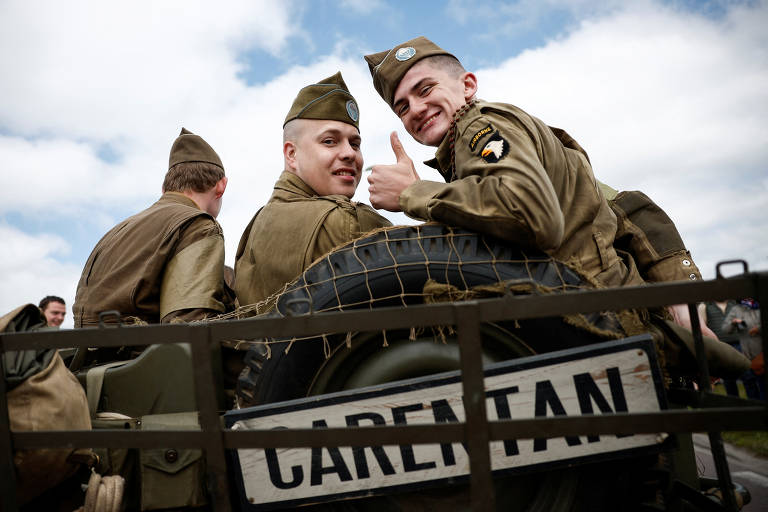 Atores como soldados americanos em encenação do Dia D em Carentan, na França