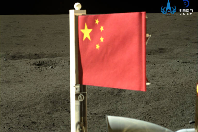 A bandeira vermelha da China com cinco estrelas amarelas é exibida na superfície lunar. A imagem captura um momento de exploração espacial, com o solo lunar acinzentado e o vácuo do espaço ao fundo.
