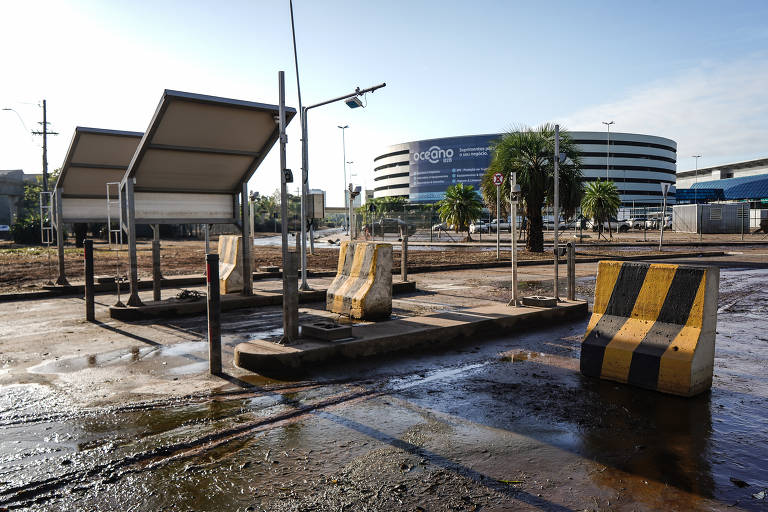 Equipamentos do aeroporto; nos campos laterais à pista a água ainda está acumulada, e a vegetação que era verde está queimada ou escurecida.