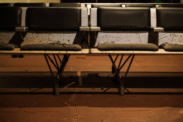 Bancos de espera sujos de barro, folhas e pequenos galhos