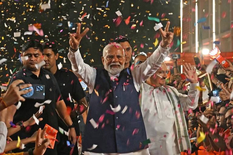 O primeiro-ministro da Índia, Narendra Modi, faz sinal de vitória ao chegar à sede do BJP (Partido Bharatiya Janata) para comemorar a vitória do partido nas eleições gerais do país, em Nova Delhi 