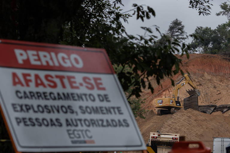 Funcionários da CCR colocam pneus para conter detritos da detonação de uma rocha no km 230 da subida da Serra das Araras, na rodovia presidente Dutra, no sentido São Paulo