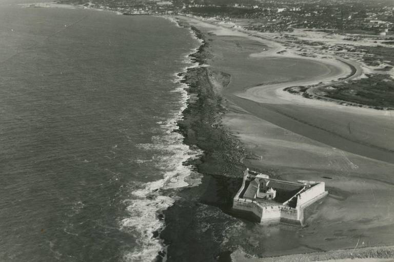 foto aérea mostra orla de praia em Natal, no Rio Grande do Norte, com construção em primeiro plano na parte inferior da imagem