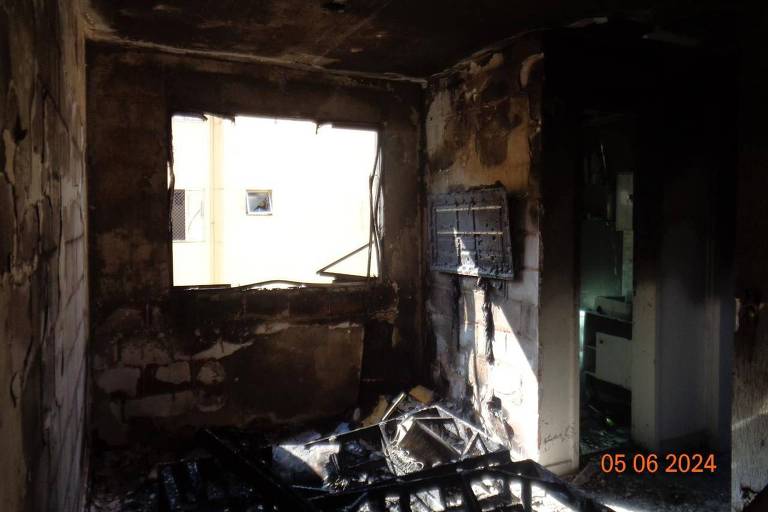 Imagem mostra um quarto totalmente queimado por um incêndio, com destroços de uma cama
