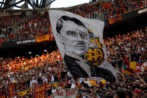AS Roma supporters wave a flag, bearing the portrait of the team founder Italo Foschi, ahead of the UEFA Europa League final football match between Sevilla FC and AS Roma at the Puskas Arena in Budapest on May 31, 2023. (Photo by Odd ANDERSEN / AFP)