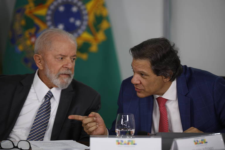 O presidente Lula ao lado do ministro da Fazenda, Fernando Haddad, em cerimônia no palácio do Planalto. 