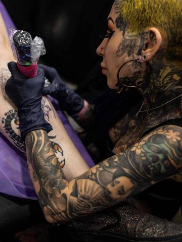Artist Alexandra Fische works on a client's tattoo at the Dallas Tattoo Festival in the Irving Convention Center in Irving, Texas, on June 2, 2024. (Photo by ANDREW CABALLERO-REYNOLDS / AFP)