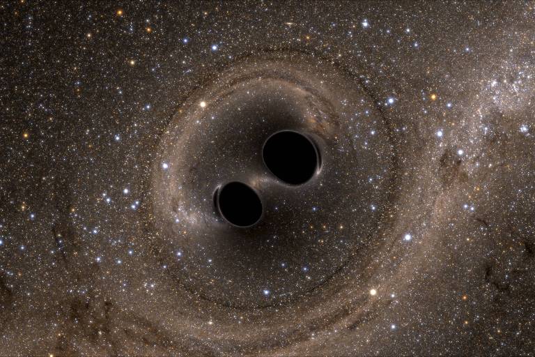 A imagem captura a representação artística de dois buracos negros em uma espécie de dança, cercados por um turbilhão de estrelas e poeira cósmica. As distorções gravitacionais criam padrões ondulados no espaço-tempo, ilustrando a poderosa interação entre esses gigantes invisíveis