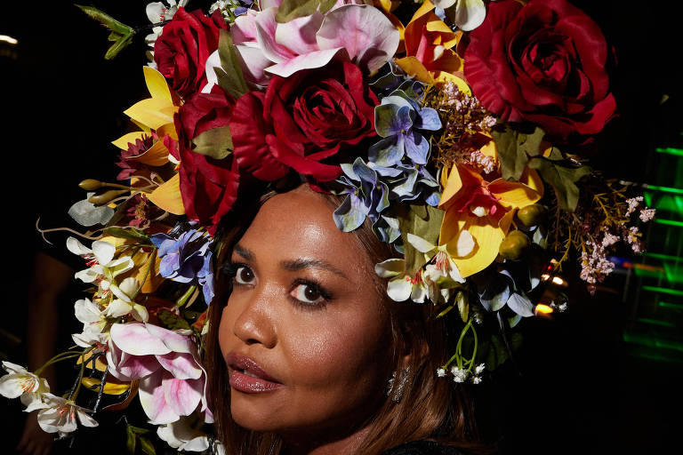 A imagem mostra uma mulher com um arranjo grande de flores na cabeça