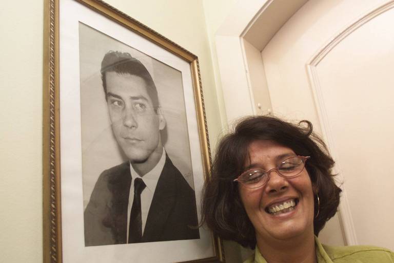 Renata Covas Lopes ao lado de retrato de seu pai, o ex-governador Mário Covas