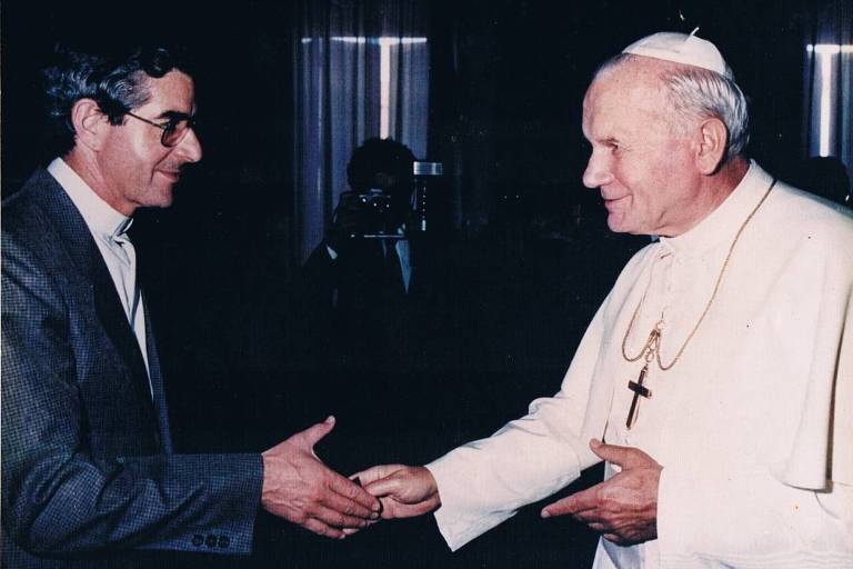 Padre Humberto Capobianco à esquerda, de terno escuro e óculos e Papa João Paulo II, de branco com crucifixo no pescoço, à direita