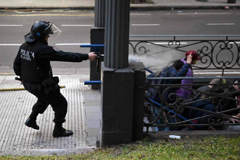 Policial usa gás de pimenta contra manifestantes na avenida 9 de Julio, em Buenos Aires