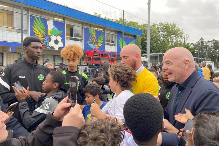 Gianni Infantino, presidente da Fifa, é cercado por crianças na inauguração do Stade Pelé, em Paris