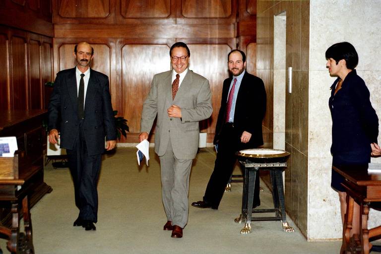 Já com FHC eleito presidente, o ministro da Fazenda, Pedro Malan (centro), e o presidente do Banco Central, Armínio Fraga (à dir.), saem do ministério da Fazenda, em Brasília (DF), para a cerimônia de comemoração dos cinco anos do Plano Real