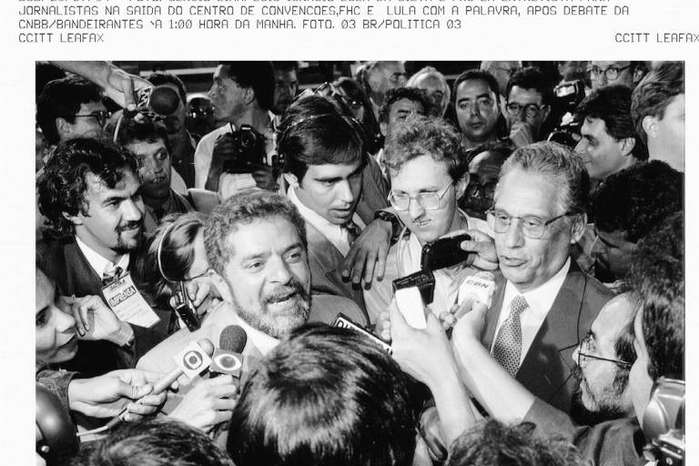 Na eleição de 1994, Luiz Inácio Lula da Silva, então candidato do PT, e Fernando Henrique Cardoso, então candidato do PSDB, debatem o plano real cercados de repórteres