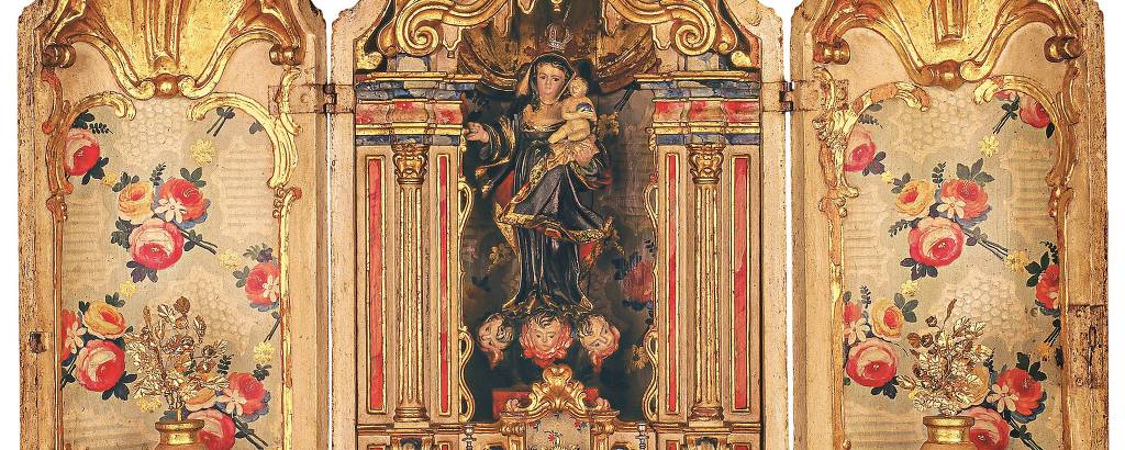 um oratório barroco portátil ricamente decorado, com painéis laterais que apresentam pinturas florais e um compartimento central que abriga uma figura religiosa