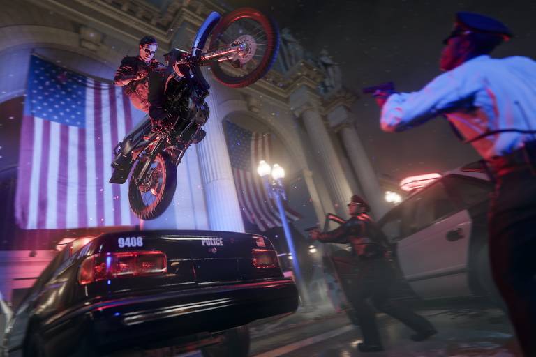 Um motociclista executa uma manobra ousada, saltando sobre um carro de polícia em um ambiente interno adornado com uma grande bandeira americana ao fundo, enquanto um policial observa a cena em movimento, com uma expressão de surpresa e admiração.