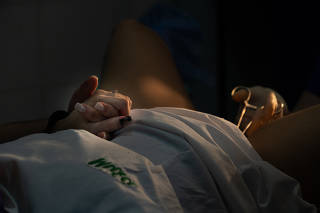Médica dá a mão a paciente brasileira durante procedimento de aborto em Rosário