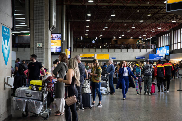 Diversas pessoas com malas retornado e indo viajar no Aeroporto Internacional de Guarulhos