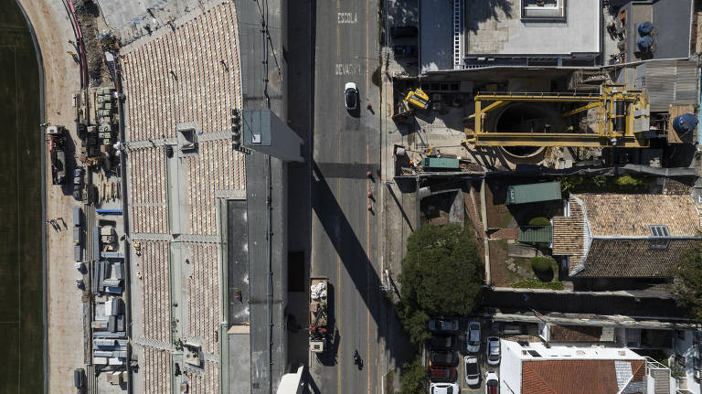 Imagem feita por drone do estádio do Pacaembu, ou Arena Mercado Livre; concessionária do estádio levantou a hipótese de que a rachadura numa pilastra tenha sido provocada pela obra do metrô, visível parcialmente à direita da imagem; empresa também solicitou reparos na calçada