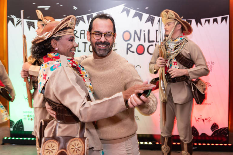 Na foto, o chef Onildo Rocha aparece dançando com uma mulher vetida de cangaceira. Ao fundo, dois homens com roupa de cangaceiro completam a cena