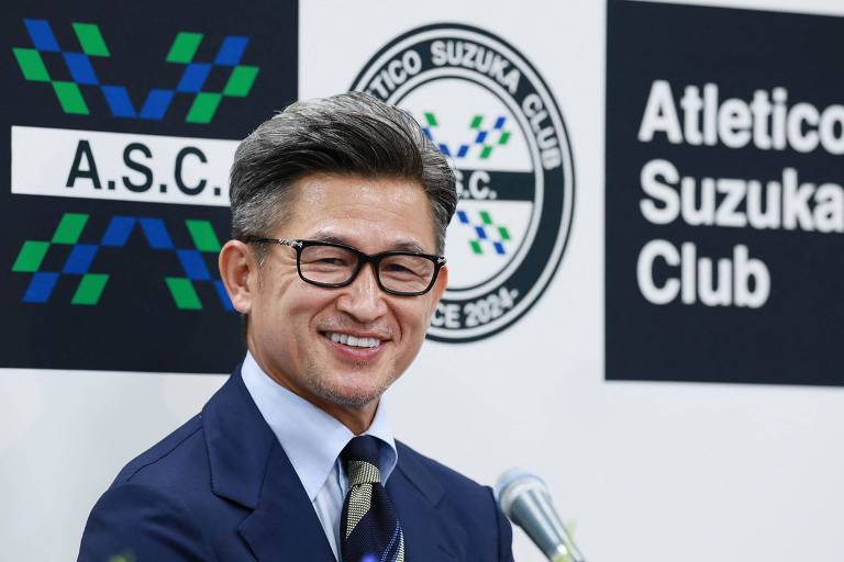 Kazuyoshi Miura, o Kazu, de 57 anos, sorri na entrevista em Tóquio em que foi anunciado como jogador do Atletico Suzuka, da quarta divisão do Japão; ele sorri e usa óculos