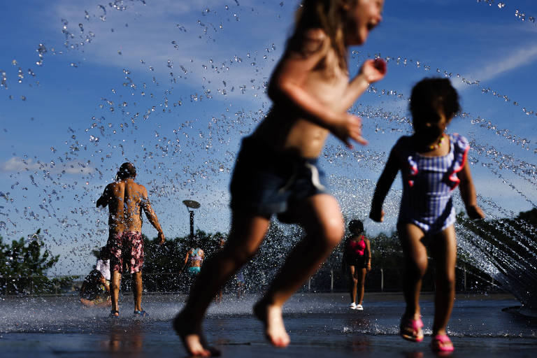 Pessoas se refrescando em uma fonte