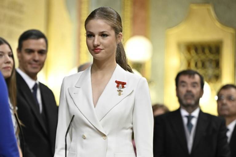 Em foto colorida, mulher de terno branco posa em cerimônia real espanhola