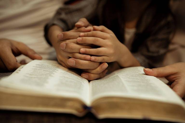 Um padre ensina uma menina a rezar