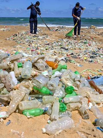 (FILES) In this file photo taken on June 05, 2020 Police Environmental Protection Division officers take part in a beach clean-up effort to remove waste and garbage on the United Nations' World Environment Day at Mount Lavinia on the outskirts of Colombo on June 5, 2020. - Plastic has infiltrated all parts of the ocean and is now found 