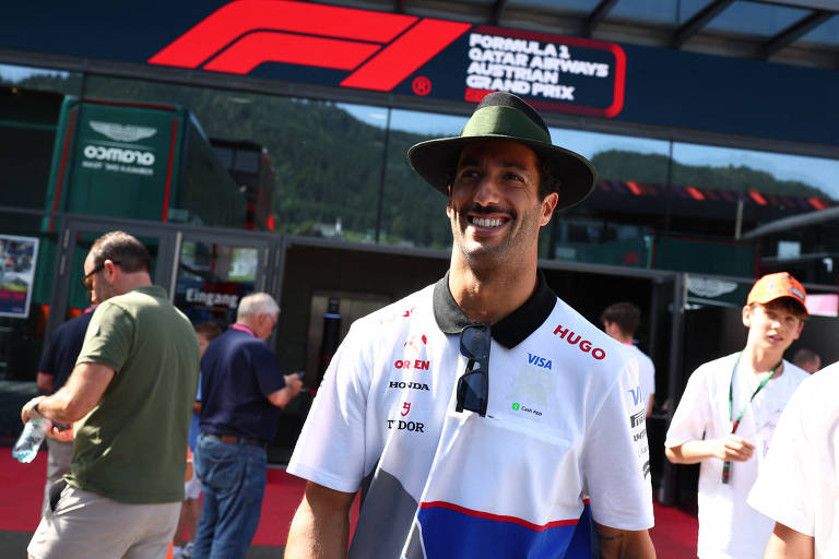 Daniel Ricciardo, de chapéu e bigode, chega para o GP da Áustria de F1