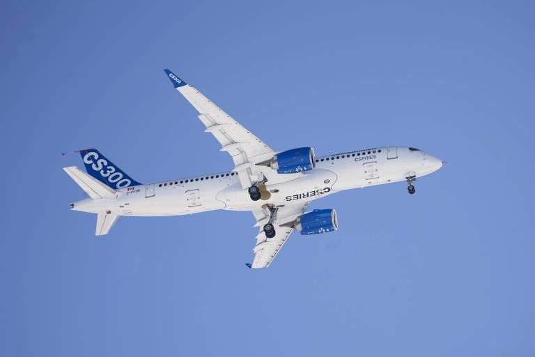 Imagem de um avião modelo CS300 em voo, com a fuselagem branca e detalhes em azul. As palavras 'CSERIES' e 'CS300' estão visíveis na lateral e na cauda do avião, respectivamente. O céu ao fundo está claro e sem nuvens.