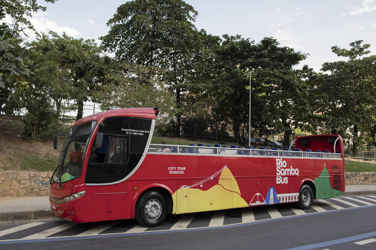 ônibus vermelho com teto aberto estacionado na rua no Rio, com desejo do morro do Pão de Açúcar