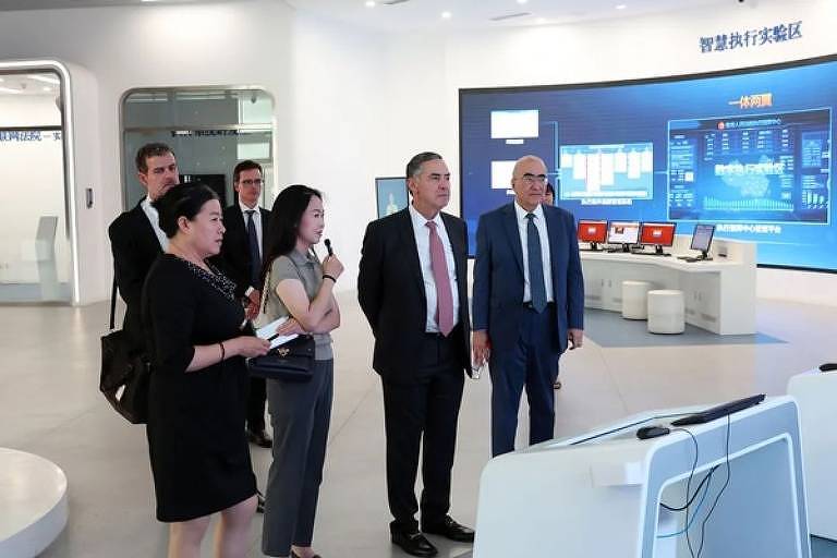 O presidente do Supremo, Luís Roberto Barroso (centro), e o embaixador brasileiro Marcos Galvão (dir.) no Laboratório do Tribunal Digital do Supremo Tribunal Popular da China, em Pequim, em 1º de julho de 2024
