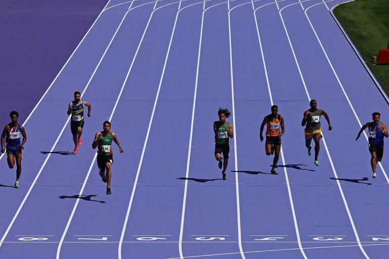 A imagem mostra uma corrida de atletismo com seis corredores em uma pista azul. Cada corredor está em sua respectiva raia, e todos estão em movimento. A pista tem linhas brancas que delimitam as raias. No canto superior direito, há uma área de grama verde