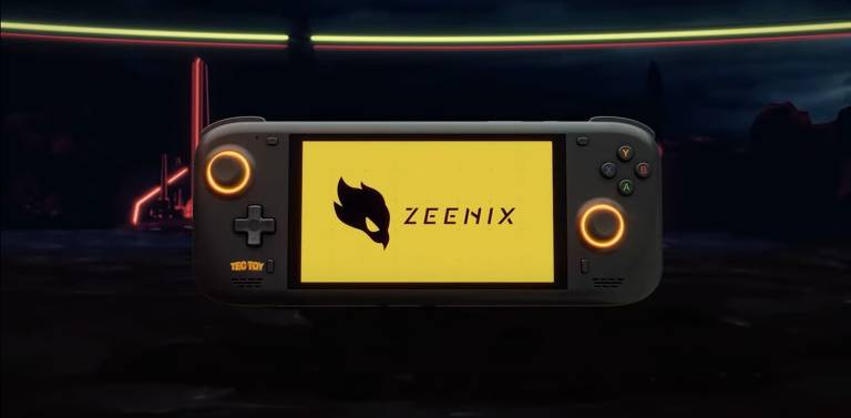 Imagem de um console portátil com a tela ligada exibindo o logotipo e o nome 'ZEENIX' em um fundo amarelo. O console possui dois joysticks circulares iluminados em laranja, um à esquerda e outro à direita. À esquerda, há também um direcional em forma de cruz e o logotipo 'TECTOY' na parte inferior. À direita, há quatro botões coloridos rotulados como Y, X, B e A. O fundo da imagem é escuro com luzes neon ao fundo.