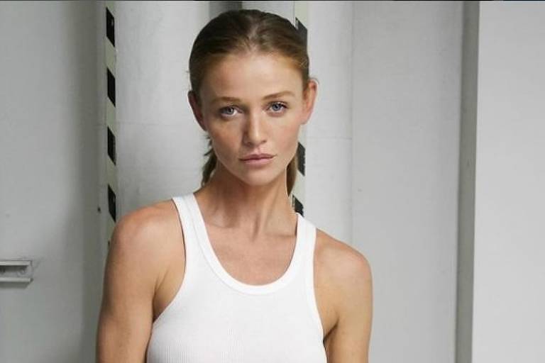 Em foto colorida, mulher posa de calça jeans e blusa branca