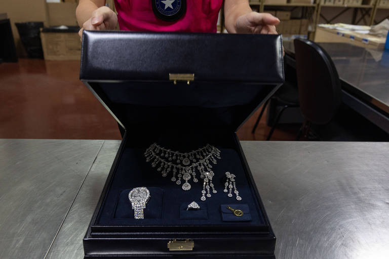 caixa azul com joias, incluindo um relogio